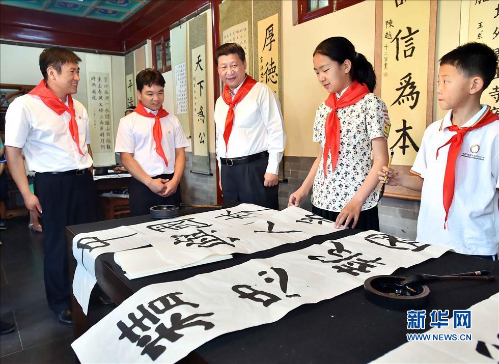 習近平觀看學生書寫的毛筆字。